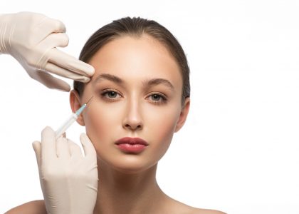 Calm young girl is getting hyaluronic acid treatment. Female hand injecting into her facial skin. Isolated and copy space in right side